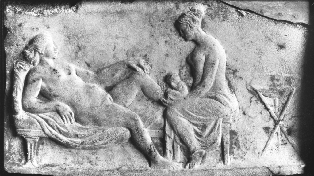 ancient roman carving of a midwife delivering baby
