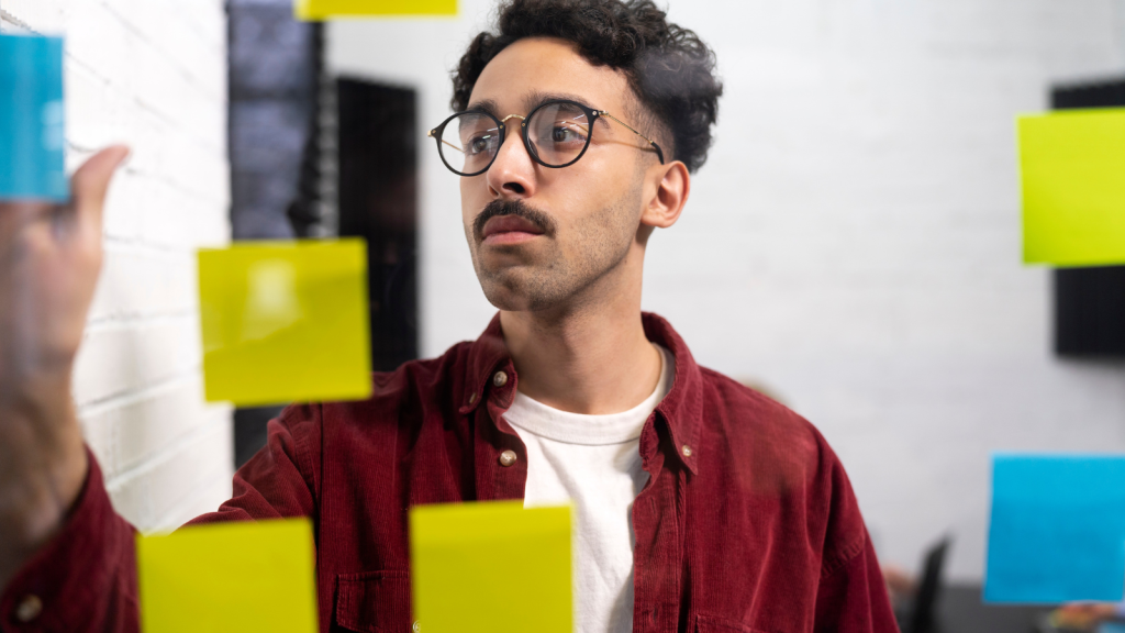 Man posting sticky notes and brainstorming