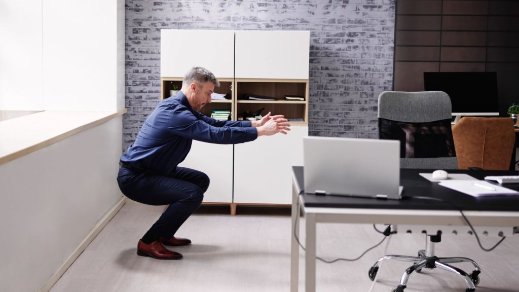 Woman Doing Exercise In Front Of Computer At Office