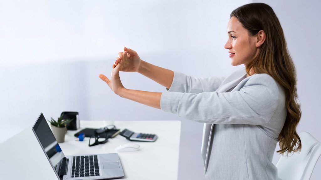 Woman Doing Stretch Exercise At Office Desk