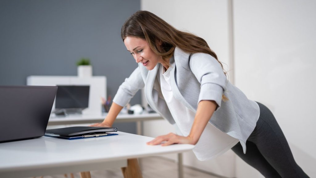 Woman doing exercise using office table