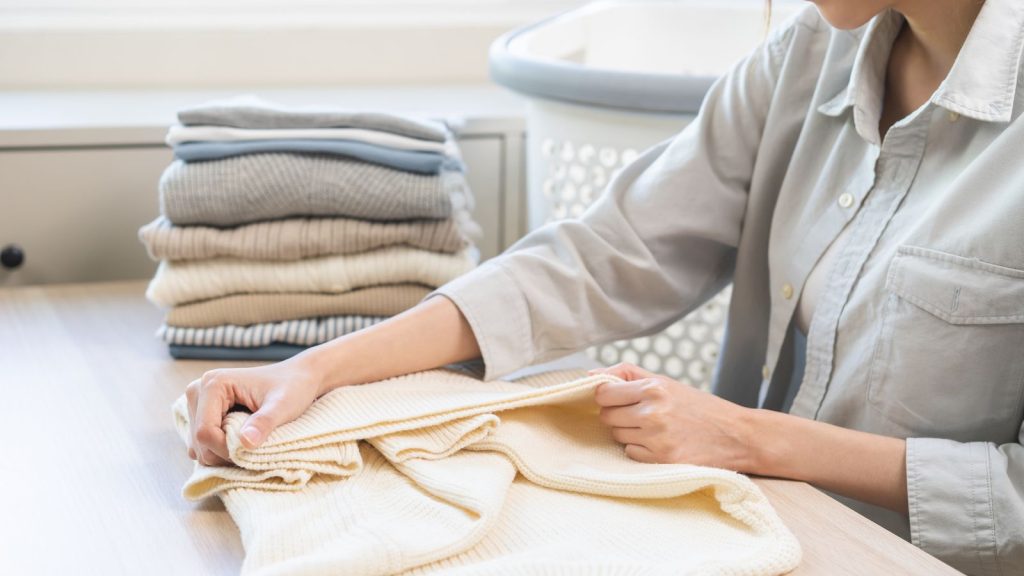 Woman folding clothes at a home designated folding station