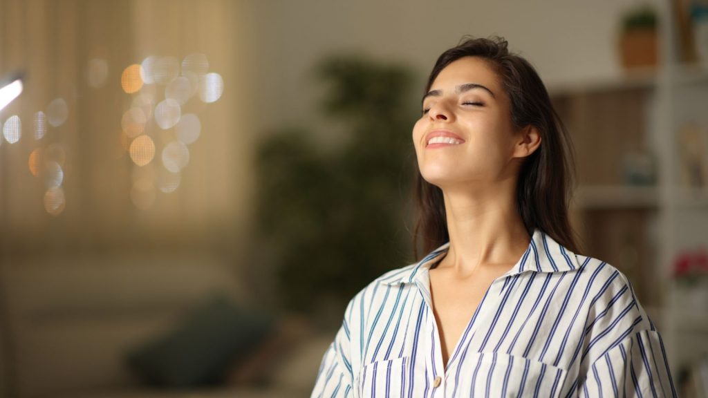 Woman sitting upright inhaling air upward