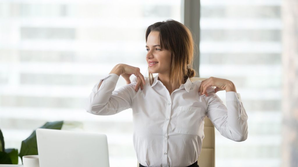 Woman squeezing her shoulders