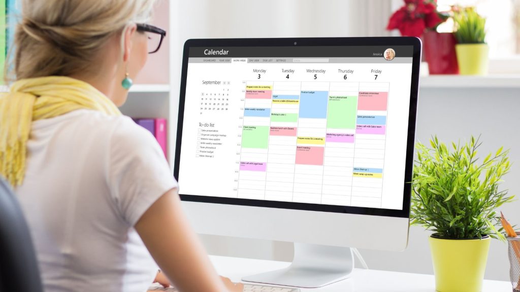 Woman using calendar app on computer in office