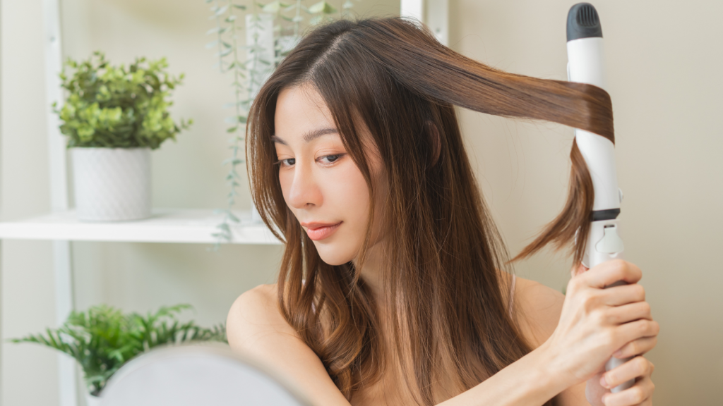 Woman using curling iron on hair