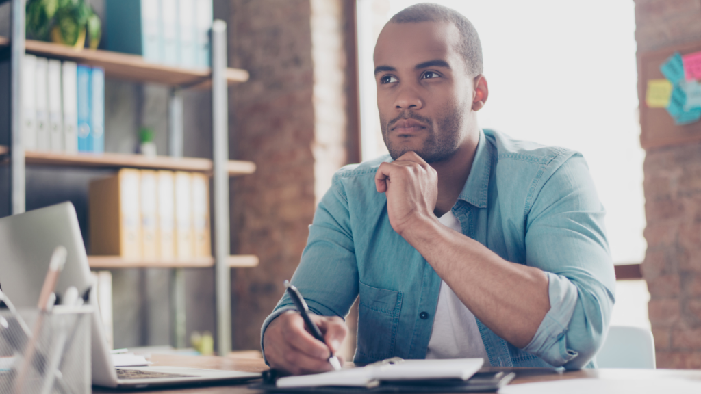 Young man is making decision sitting at the office in casual smart