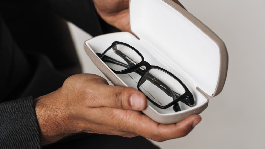 man wearing suit showing glasses in case