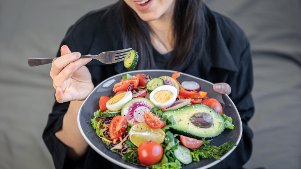 appetizing salad with fresh vegetables and eggs in a plate in female hands