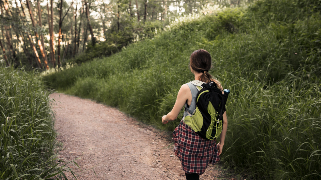 Woman with backpack walking in the forest