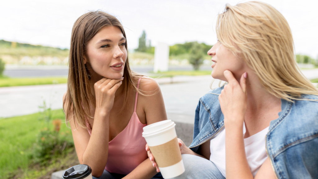 best friends talking while holding some paper cups of coffee