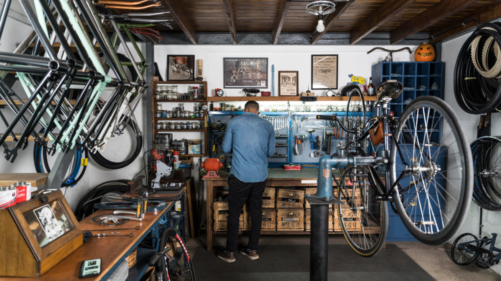 a person inside the garage with hanged bicycle and tools