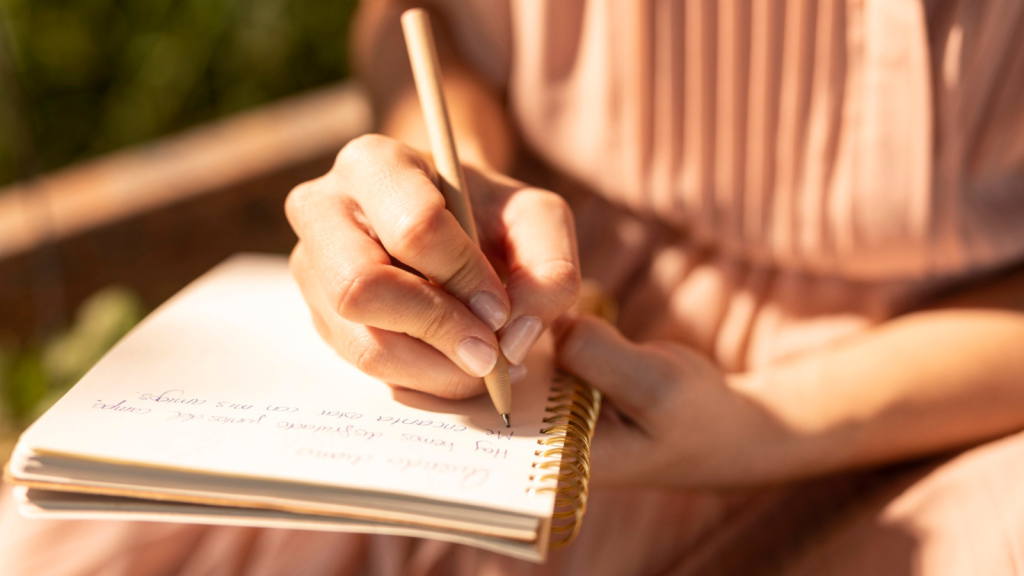 close up shot of a woman's hand writing in a notebook