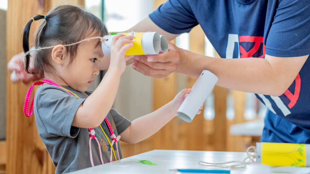 Little girl making tissue paper core binoculars