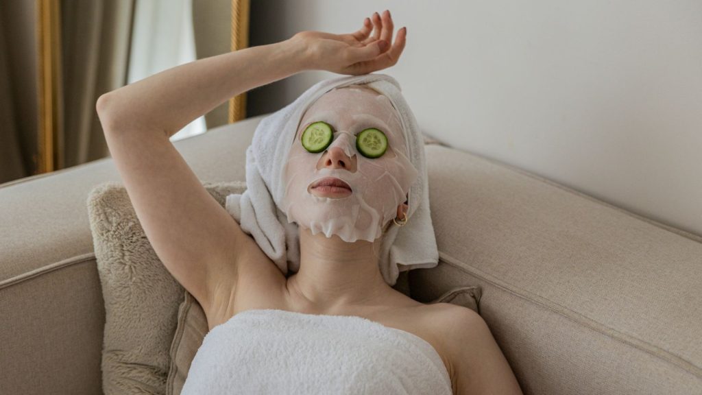 woman has beauty mask and cucumber in her eyes