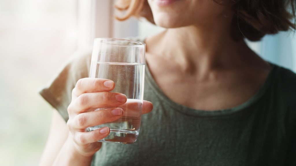 woman holding a glass of water