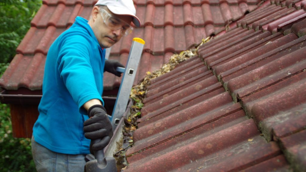 professional worker cleaning up the gutter