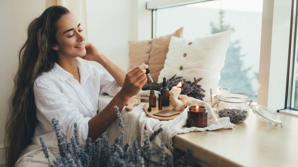 Young woman holding natural organic essential oil