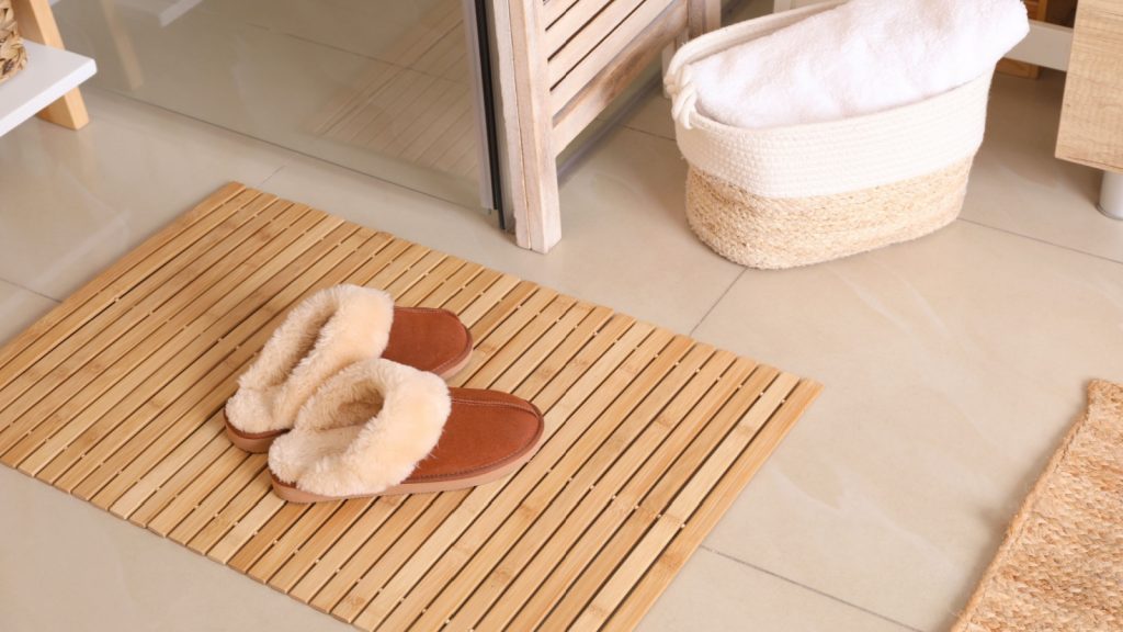 bamboo mat and slippers on tiled floor in bathroom