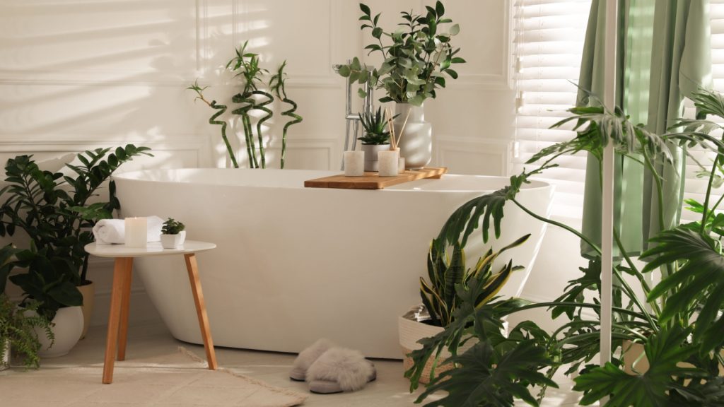 bathroom with white tub and green houseplants