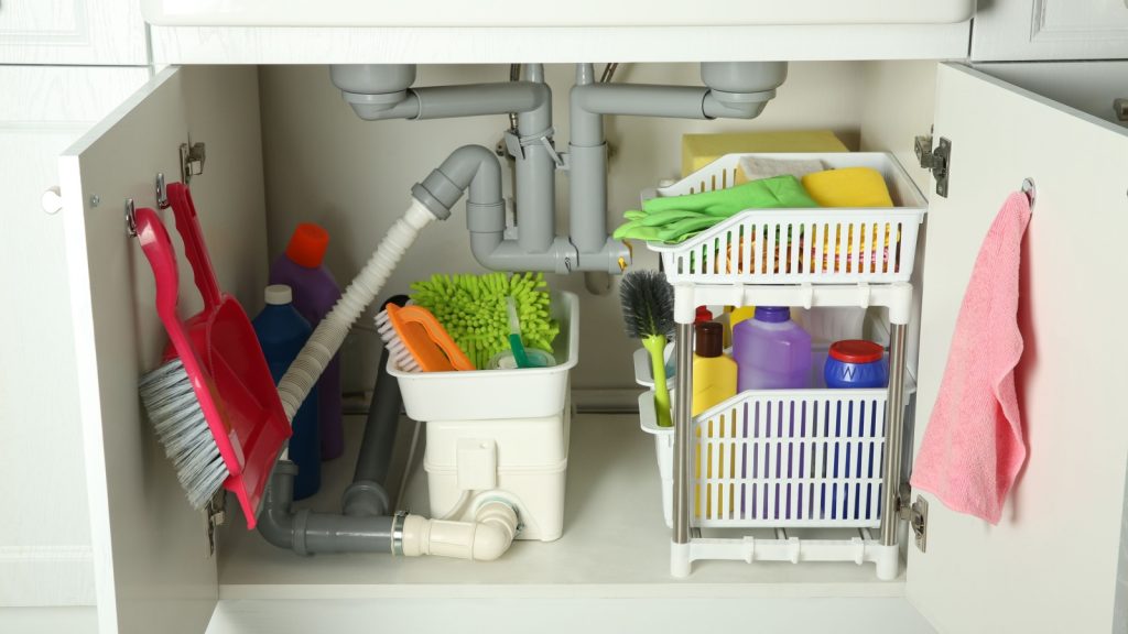 cleaning tools and supplies in a self in open cabinet under sink