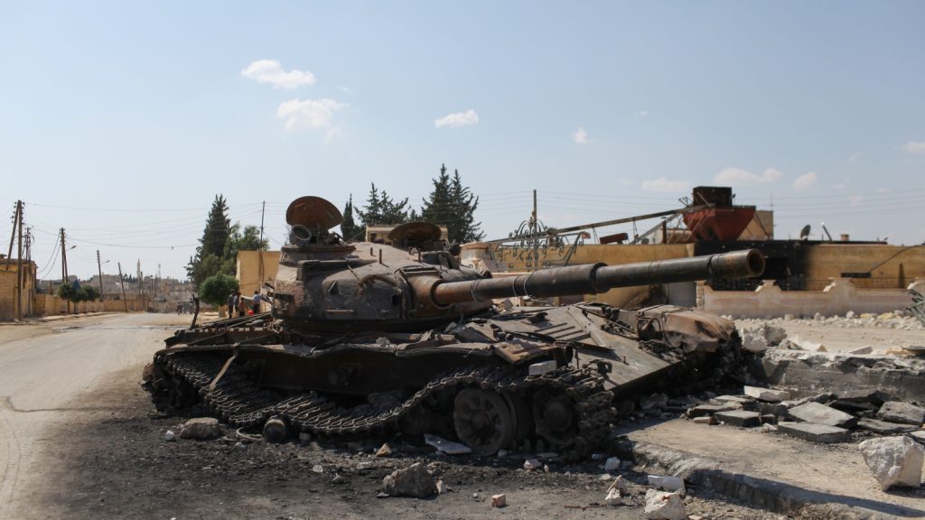 damaged tank among the heaps of destroyed building