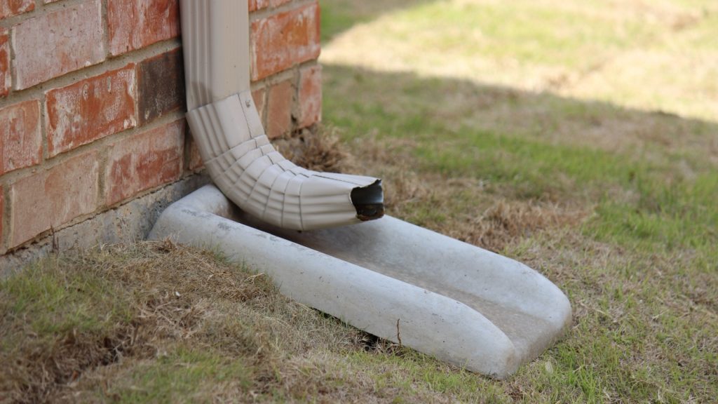 concrete splash block on grass for drain spout