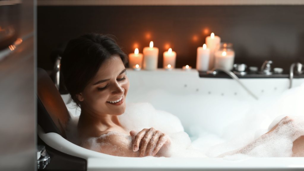 Happy woman taking bubble bath