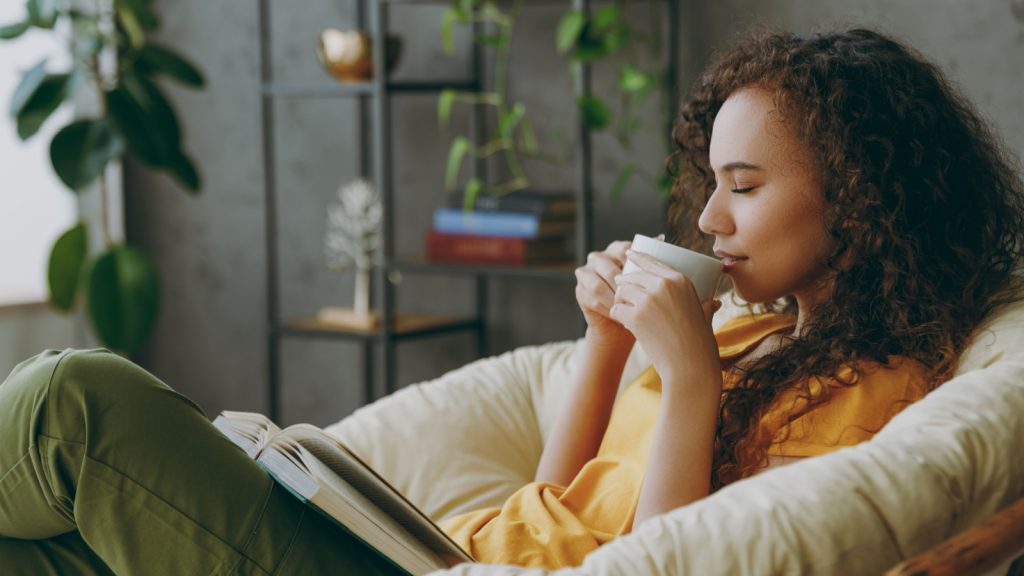 a woman with eyes closed enjoying coffee