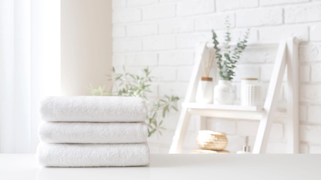 towel stack on white table on bathroom