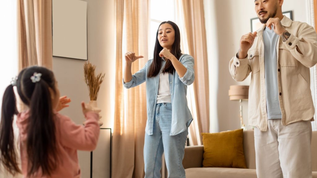 parents playing charades with their daughter