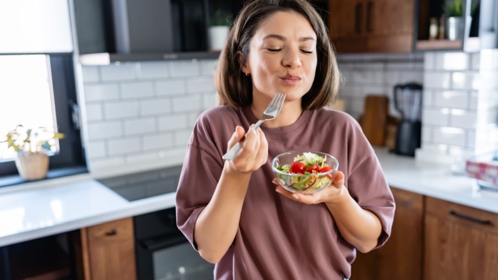 a young woman eating a salad