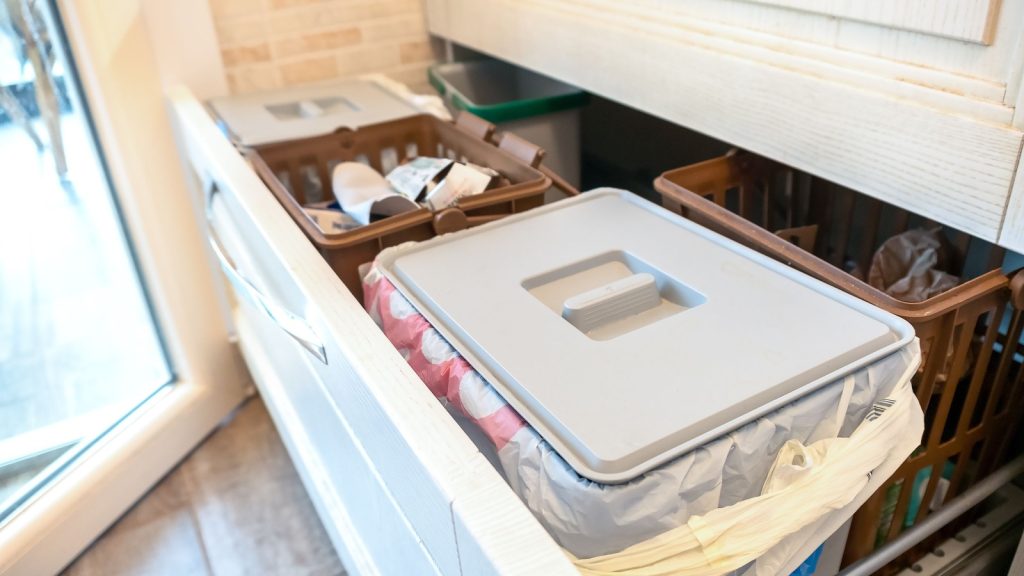 pull-out drawers under the sink with cleaning products and   trash bin