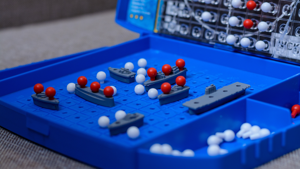 Toy warships and submarine are placed on the playing field