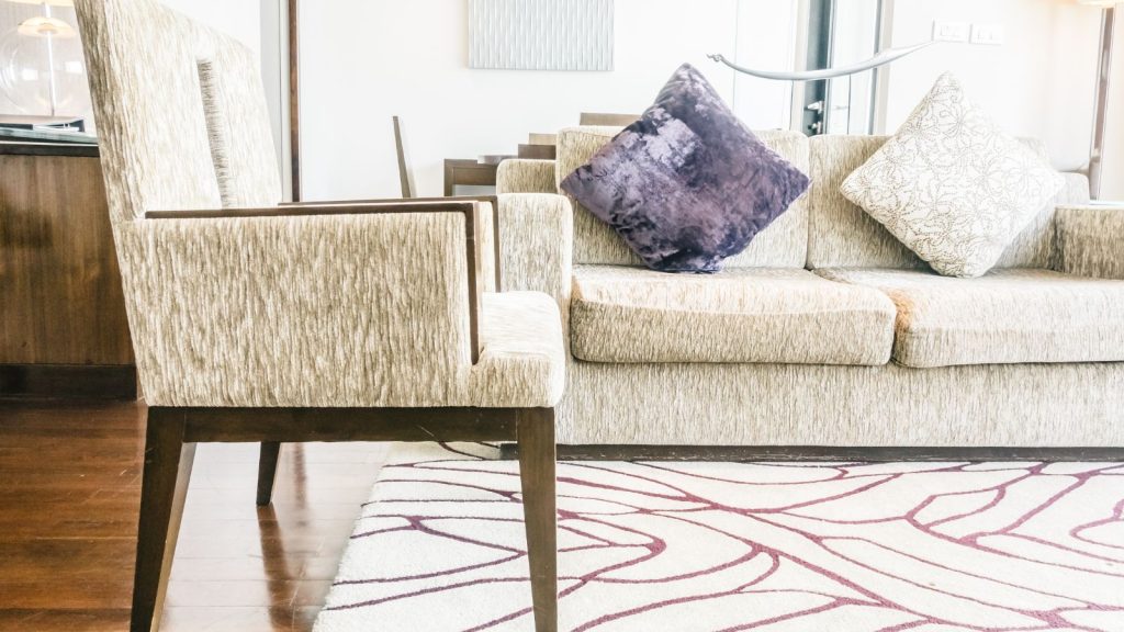 living room with rug, chair, and sofa with pillows