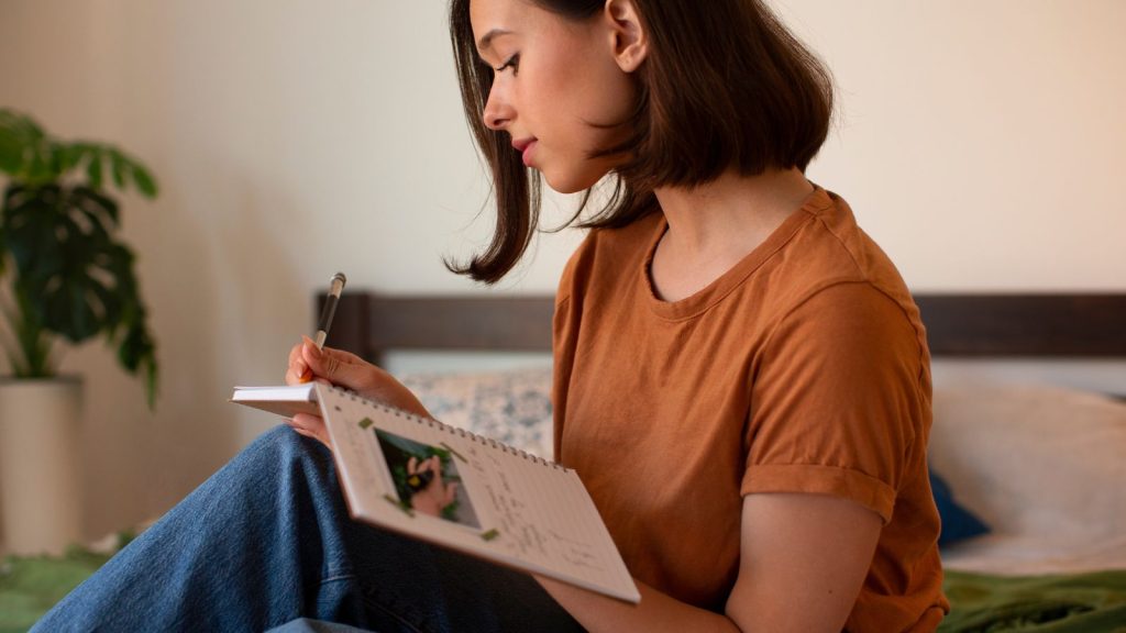 a woman writing on her creative journal