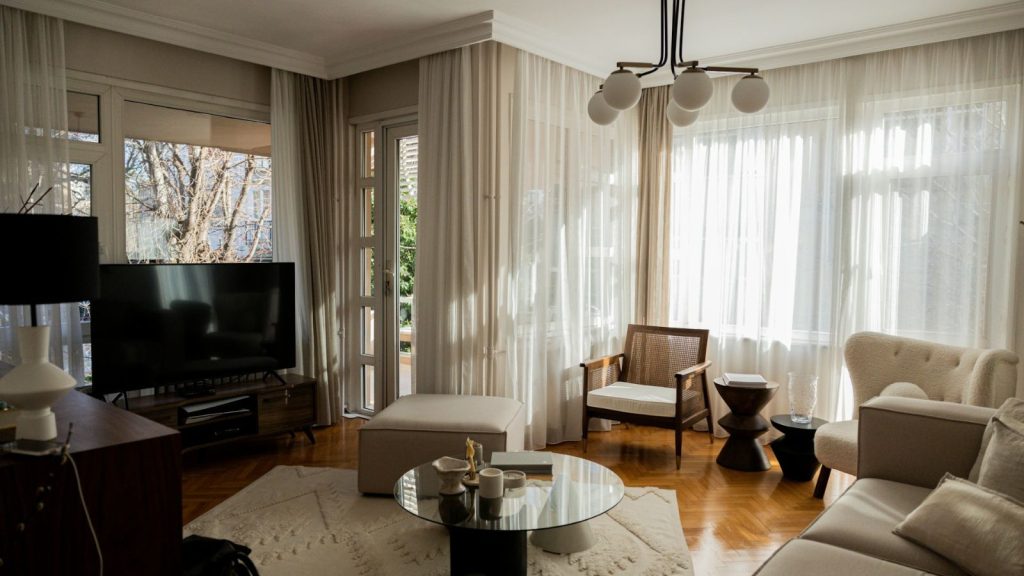 living room with curtains, sofas, and other furniture in neutral colors