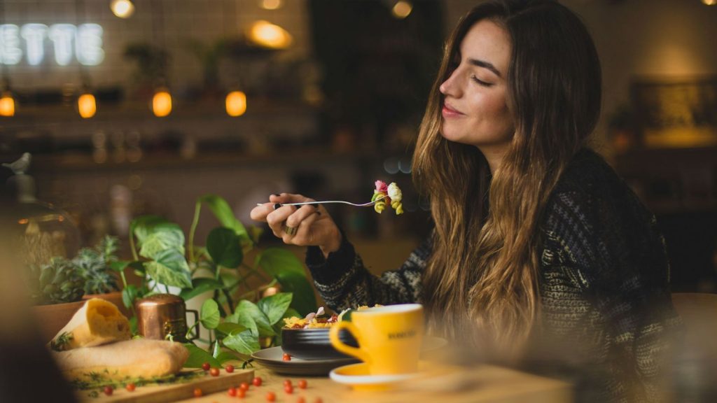 a happy woman eating a healthy meal