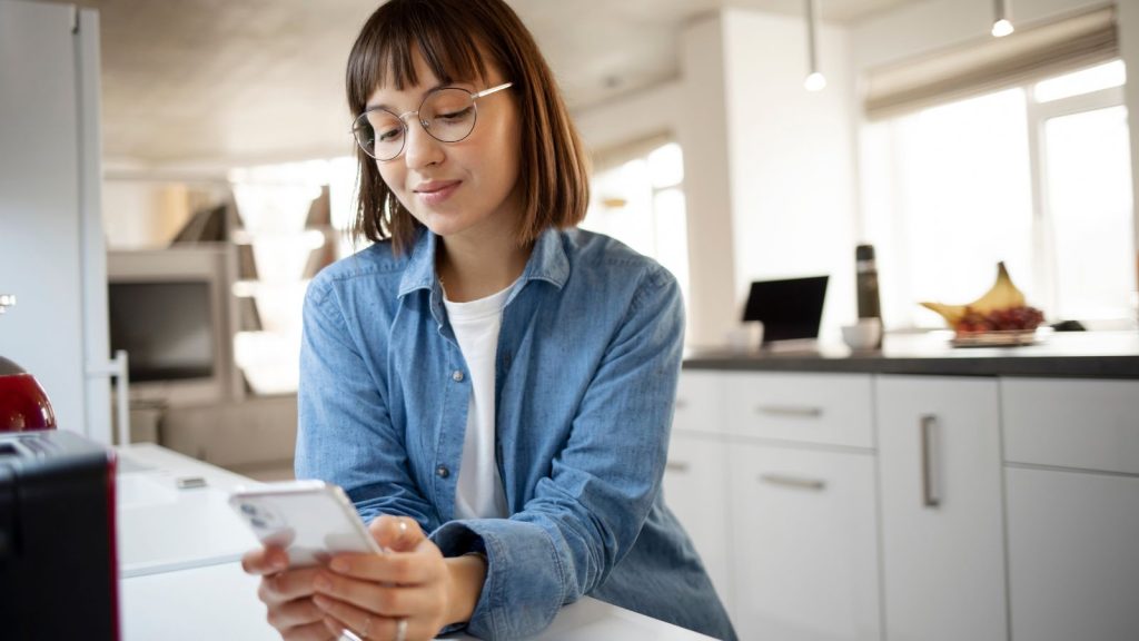 woman wearing eyeglass checking her phone