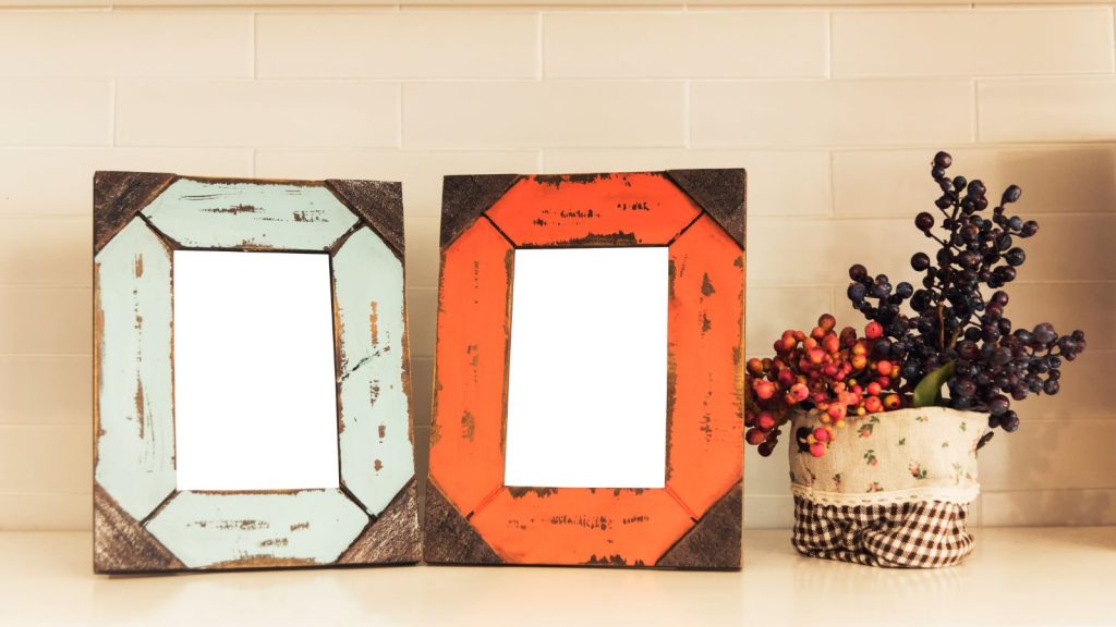 Repainted photo frames with flower pot on table.