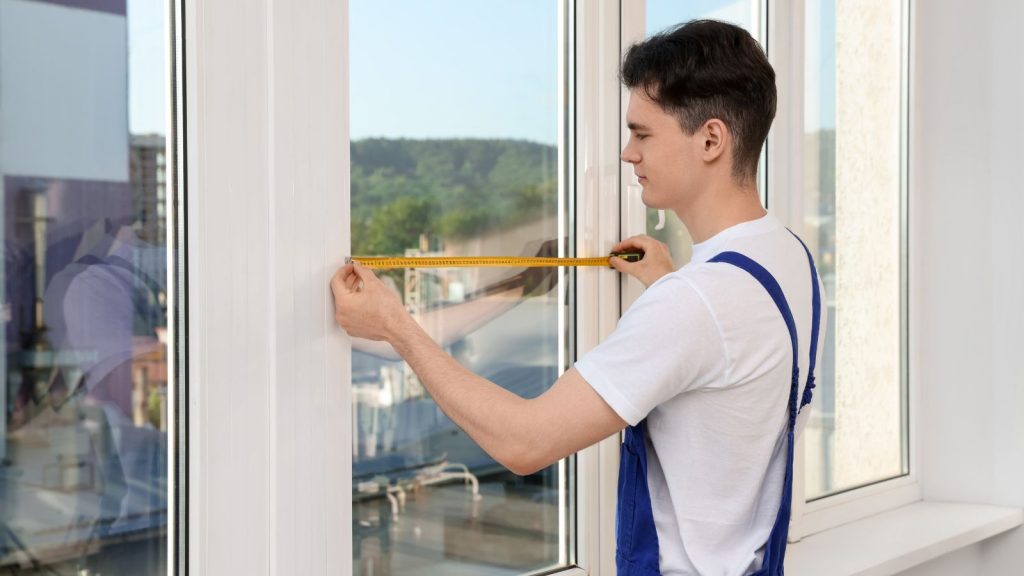 Worker measuring window indoors Installation.