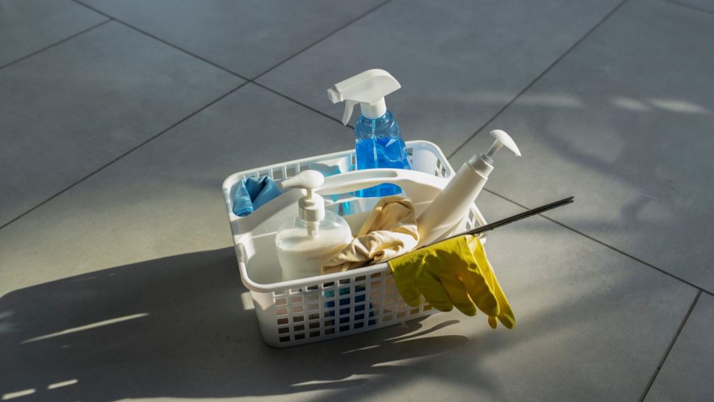 a shower caddy with cleaning supplies on the floor