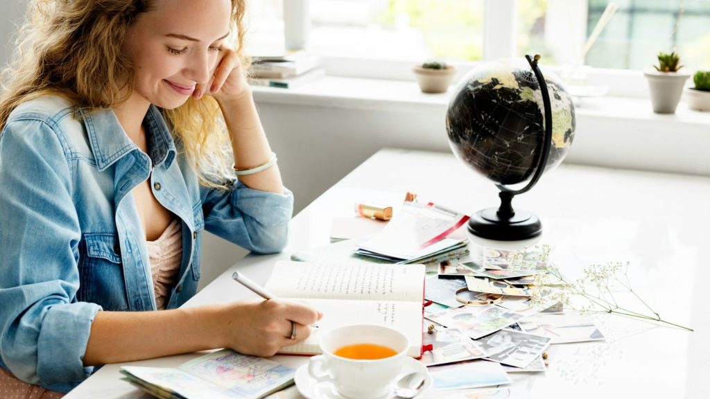 a happy woman writing on her journal