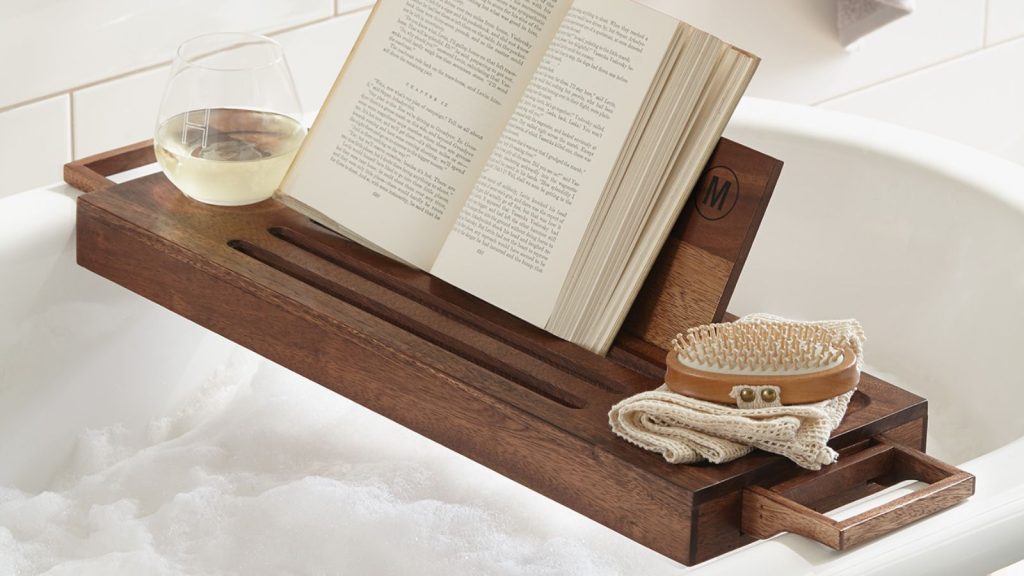 wooden bath caddy with book, scrubber, and wine glass