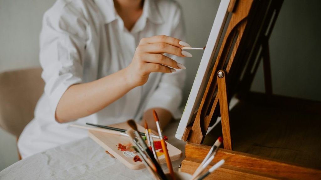 a woman holding a brush while painting