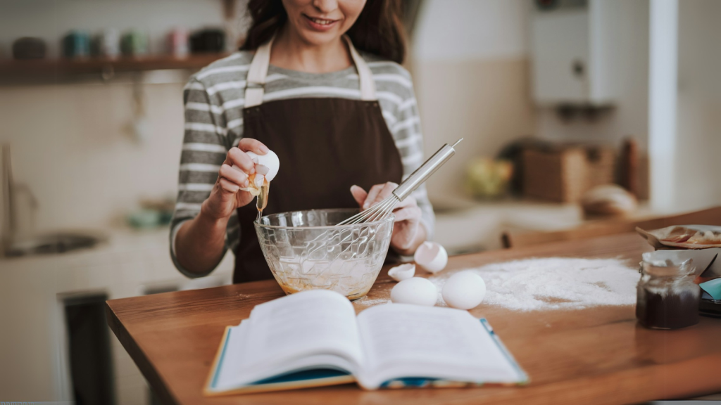 Woman baking with recipe on the table