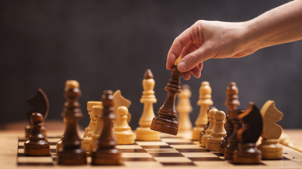 chess piece in a woman's hand on a chessboard in an office