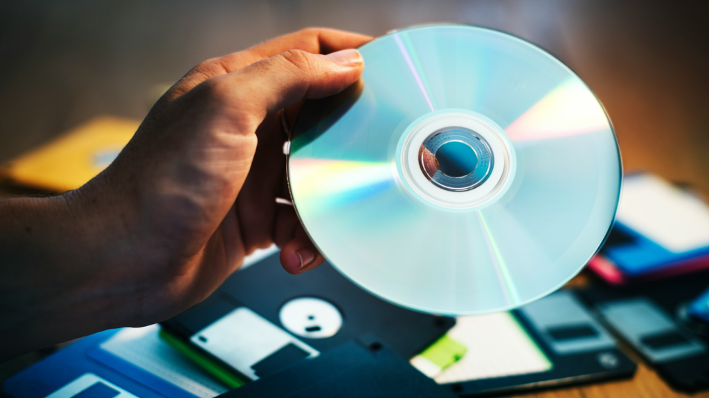 compact disk with floppy disk in the background